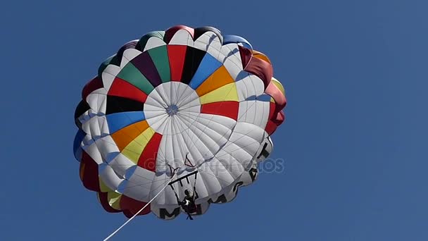 Chica vuela en el aire con un colorido paracaídas en cámara lenta — Vídeo de stock