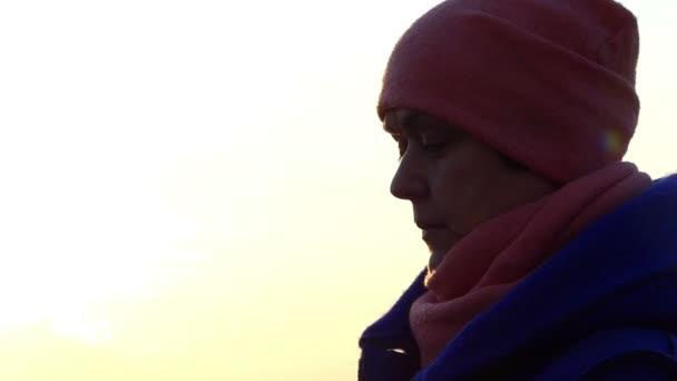 Μέσης ηλικίας γυναίκα αρχίσει να φοράει γυαλιά στο ηλιοβασίλεμα σε κρύα περίοδο. — Αρχείο Βίντεο