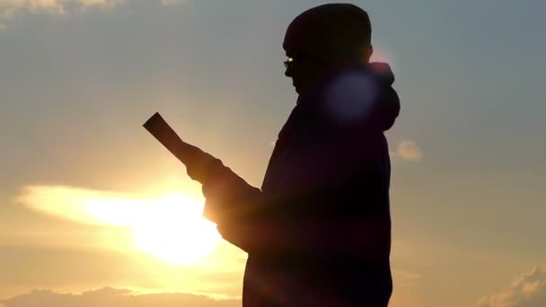 Silhuetten av kvinnor läser vid solnedgången i kalla perioden. — Stockvideo