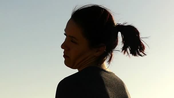 Дівчина, роблячи вправи для шиї на заході сонця в уповільненому Русі. — стокове відео