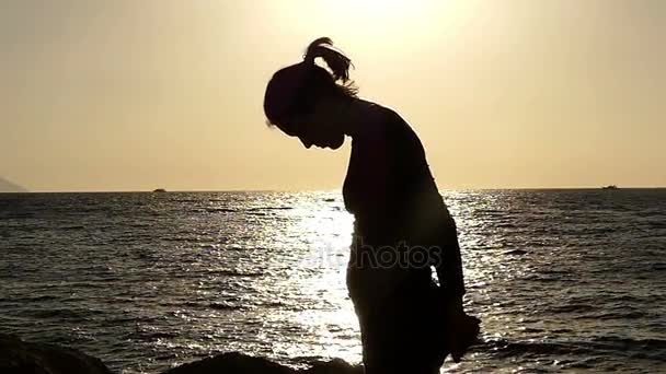 Fille fait étirement de sa poitrine au ralenti sur la plage au coucher du soleil . — Video