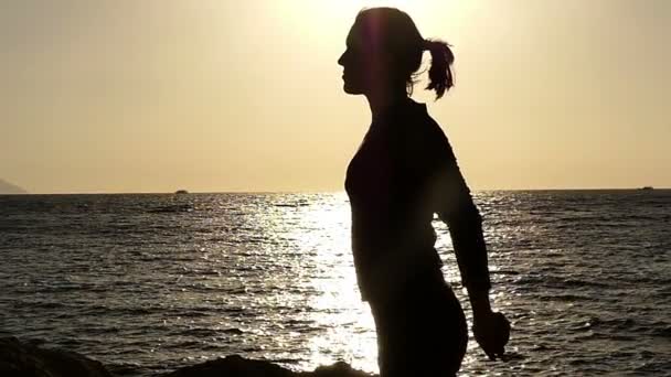 Meisje maken van Stretch van haar borst bij zonsondergang in Slow Motion op het strand. — Stockvideo