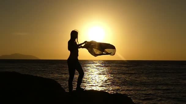 Menina bonita com Pareo em pé na praia ao pôr do sol em câmera lenta . — Vídeo de Stock