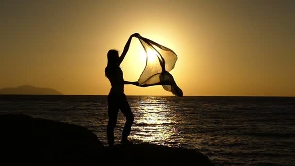 Menina bonita com Pareo em pé na praia ao pôr do sol em câmera lenta . — Vídeo de Stock