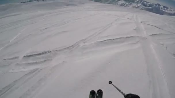 Le skieur avance rapidement, derrière les autres skieurs et snowboarders le long des hautes montagnes — Video