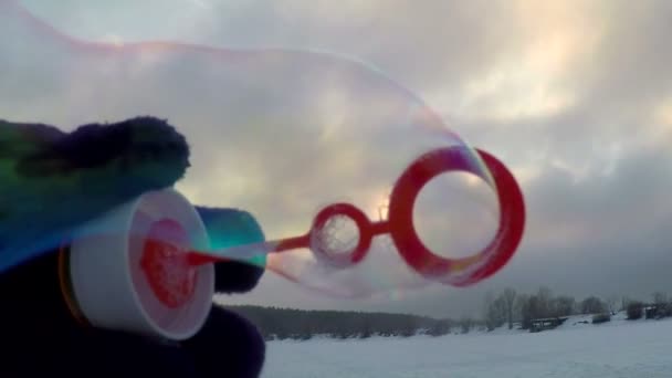 Bolhas de sabão iridescentes no fundo de uma paisagem de inverno em câmera lenta — Vídeo de Stock