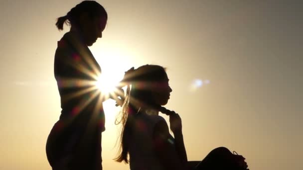Genç kadın, bir saç modeli için ikinci bir yaptığında iki Silhouettes. — Stok video