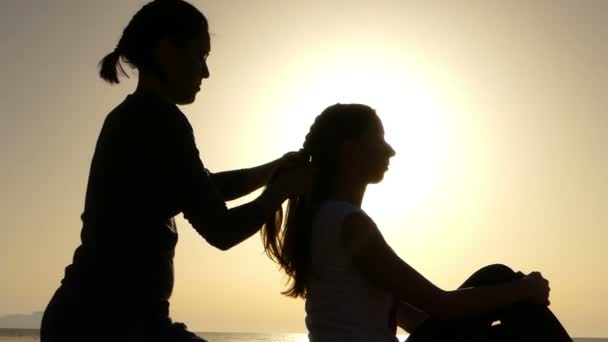 Chica trenzas coletas a otra chica al atardecer . — Vídeo de stock