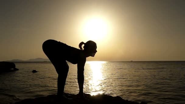 Giovane donna in piedi in profilo e fare esercizi di yoga per la schiena sana . — Video Stock