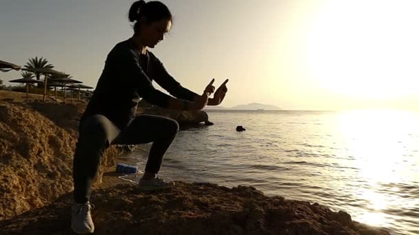 Молодая женщина, сидящая в профиле и занимающаяся восточными упражнениями в Сломо — стоковое видео