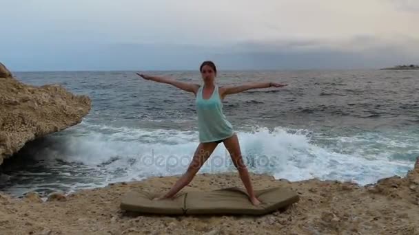 Mulher nova está fazendo a dose do triângulo do exercício do Yoga em um Seabeach . — Vídeo de Stock