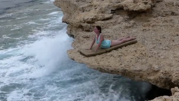 Piękna młoda kobieta robi joga Asana o nazwie 'cobra' na Stony Seabeach w Egipcie w ciągu dnia w jesieni — Wideo stockowe