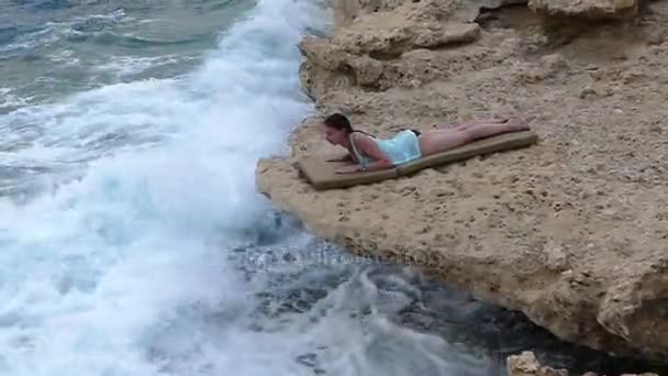 Mulher bonita como uma sereia está deitada em um salão de sol no mar pedregoso . — Vídeo de Stock