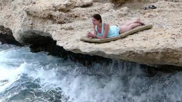 Meisje opleggen aan de klif Over zee. — Stockvideo
