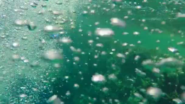 Nager derrière un plongeur sous l'eau à travers beaucoup de bulles au ralenti — Video