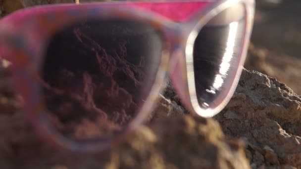 Concentrarsi sugli occhiali da sole con riflesso del bellissimo tramonto sul mare . — Video Stock
