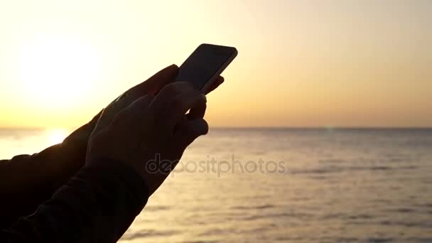 Mädchen benutzt das Telefon bei Sonnenuntergang aus nächster Nähe — Stockvideo