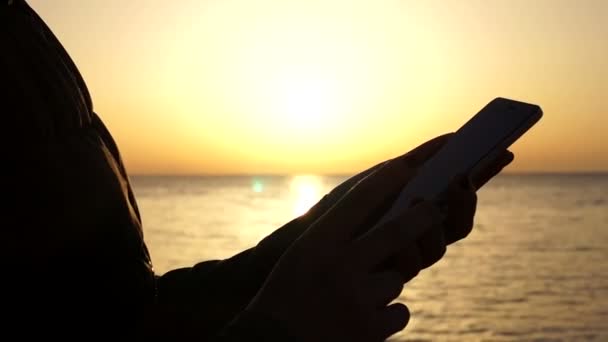 Hände benutzen das Telefon bei Sonnenuntergang aus nächster Nähe — Stockvideo