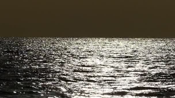 Meereslandschaft bei Sonnenuntergang mit silbrig glänzendem Wasser in Zeitlupe — Stockvideo