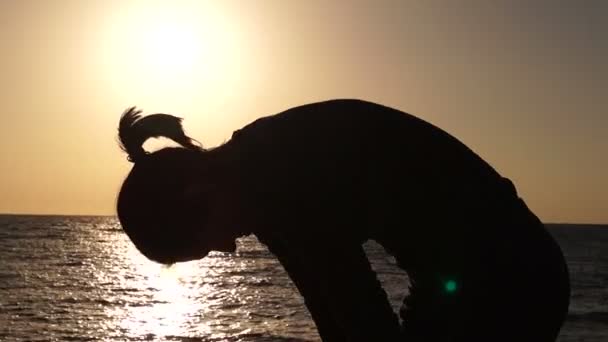 Chica se calienta al atardecer en la playa . — Vídeos de Stock