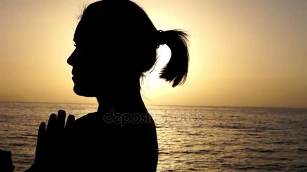 Девушка с намасте стоит на берегу моря . — стоковое видео