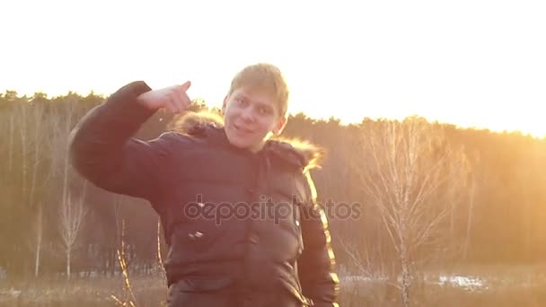 Un garçon positif montre un geste "excellent" dans le contexte du paysage printanier matinal au ralenti — Video