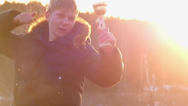 El Niño sostiene la recompensa en su mano, mientras que la segunda mano muestra el gesto "excelente" en cámara lenta — Vídeos de Stock