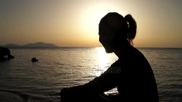 Uma menina ri no mar ao amanhecer — Vídeo de Stock