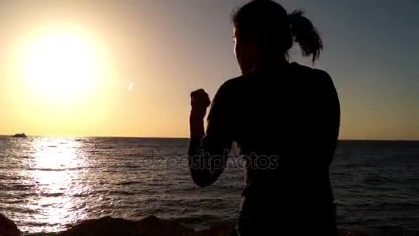 A Boxer Girl Trains Blows on the Background of the Sea — Stock Video