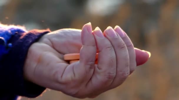 Uma mulher tem vários comprimidos na palma da mão, ela os conta e espreme a palma da mão — Vídeo de Stock