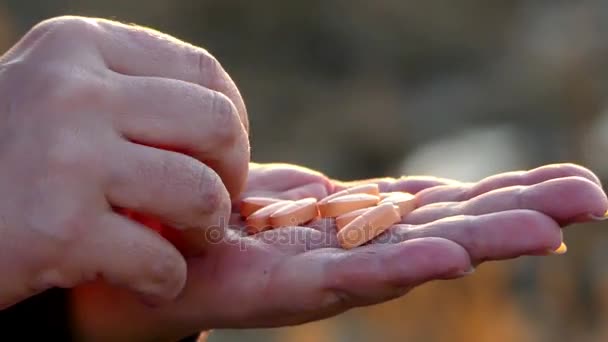 Una mujer tiene varias píldoras en la palma de su mano, las cuenta y aprieta la palma de su mano — Vídeos de Stock