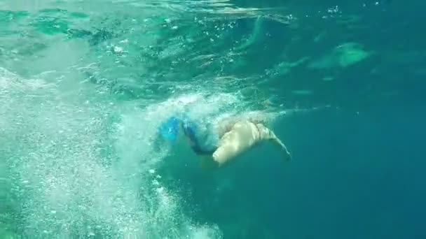 Schöne Beine Mädchen in Brustflossen schwimmen auf der Oberfläche des Meeres in Zeitlupe. — Stockvideo