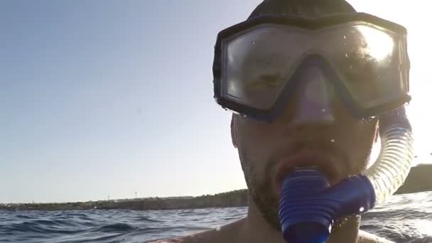 Acuario buscando peces y un joven con gafas nadando sobre un arrecife — Vídeos de Stock