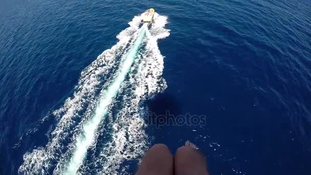 Die Füße eines Fallschirmspringers im Hintergrund des Roten Meeres und ein Motorboot in Flammen — Stockvideo