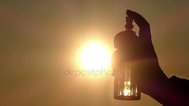 La persona rocía líquido en la botella y crea una hermosa nube de iones que se disuelven en el aire durante la puesta del sol — Vídeo de stock