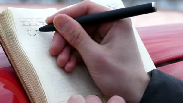 De persoon in het notitieblok schrijft in een prachtig handschrift het woord "leven" — Stockvideo