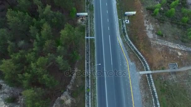 Antenn skott av en motorväg med skyltar går igenom vissa pinjeskog — Stockvideo
