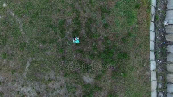 Prise de vue aérienne d'une jeune femme levant les mains et regardant un drone volant — Video