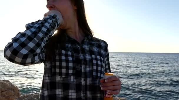 Jonge vrouw is geeuwen sluiten haar mond met een Hand op een Zeekust bij zonsondergang — Stockvideo