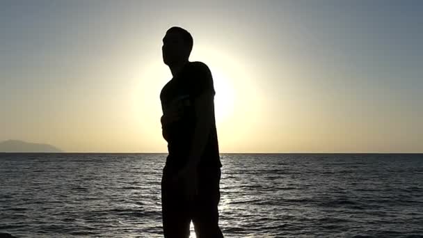 Junger Mann hält seine Hand am Herzen und schlägt bei Sonnenuntergang im Slo-mo aus der Brust — Stockvideo