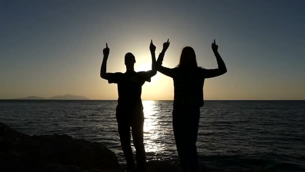 Jeune homme et jeune femme dansent sur un littoral pittoresque au coucher du soleil au ralenti — Video