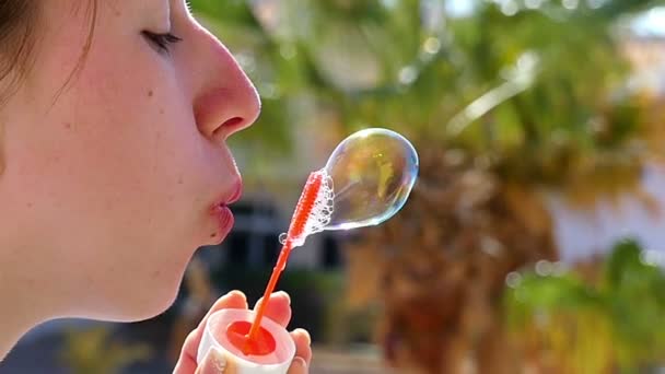 Mujer joven feliz hace una gran burbuja de jabón, que estalla repentinamente en Slo-Mo — Vídeos de Stock