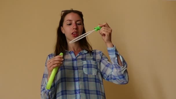 Sorrindo jovem mulher está criando bolhas de sabão com uma longa varinha de sabão em Slo-Mo — Vídeo de Stock