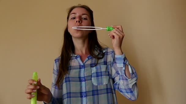 Jovem feliz está criando bolhas de sabão com uma longa varinha de sabão em Slo-Mo — Vídeo de Stock