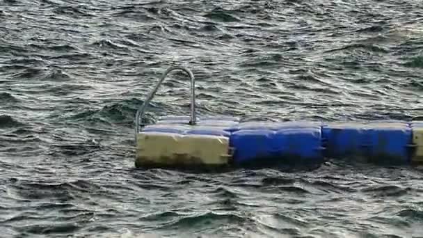 Pontón de plástico azul y blanco se balancea en las olas del mar Rojo en un día soleado — Vídeo de stock