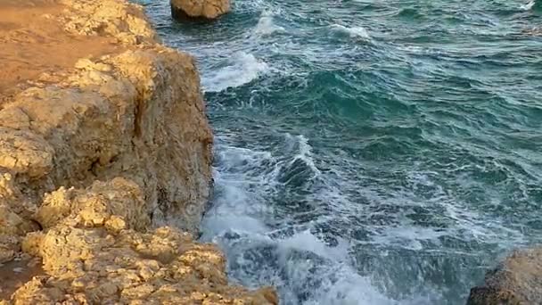 Le onde del mare schiumoso che schiantano il litorale roccioso marrone chiaro in Egitto in un giorno esposto al sole — Video Stock