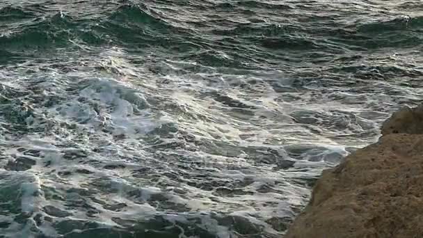 岩石的海滨和整理海浪它与及其泡沫的水在日落时分 — 图库视频影像