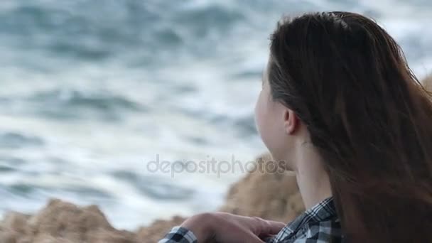 Happy Young Woman s'assoit sur un littoral rocheux et sourit à Slo-Mo en été — Video