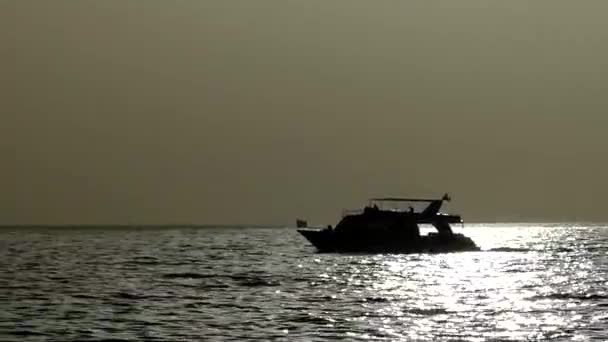 Le bateau à moteur moderne flotte lentement de profil dans les crépuscules nocturnes de la mer Rouge — Video