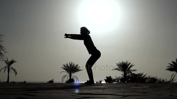 Mujer joven practica yoga, haciendo Situps, en un fondo marino en Egipto al atardecer — Vídeo de stock